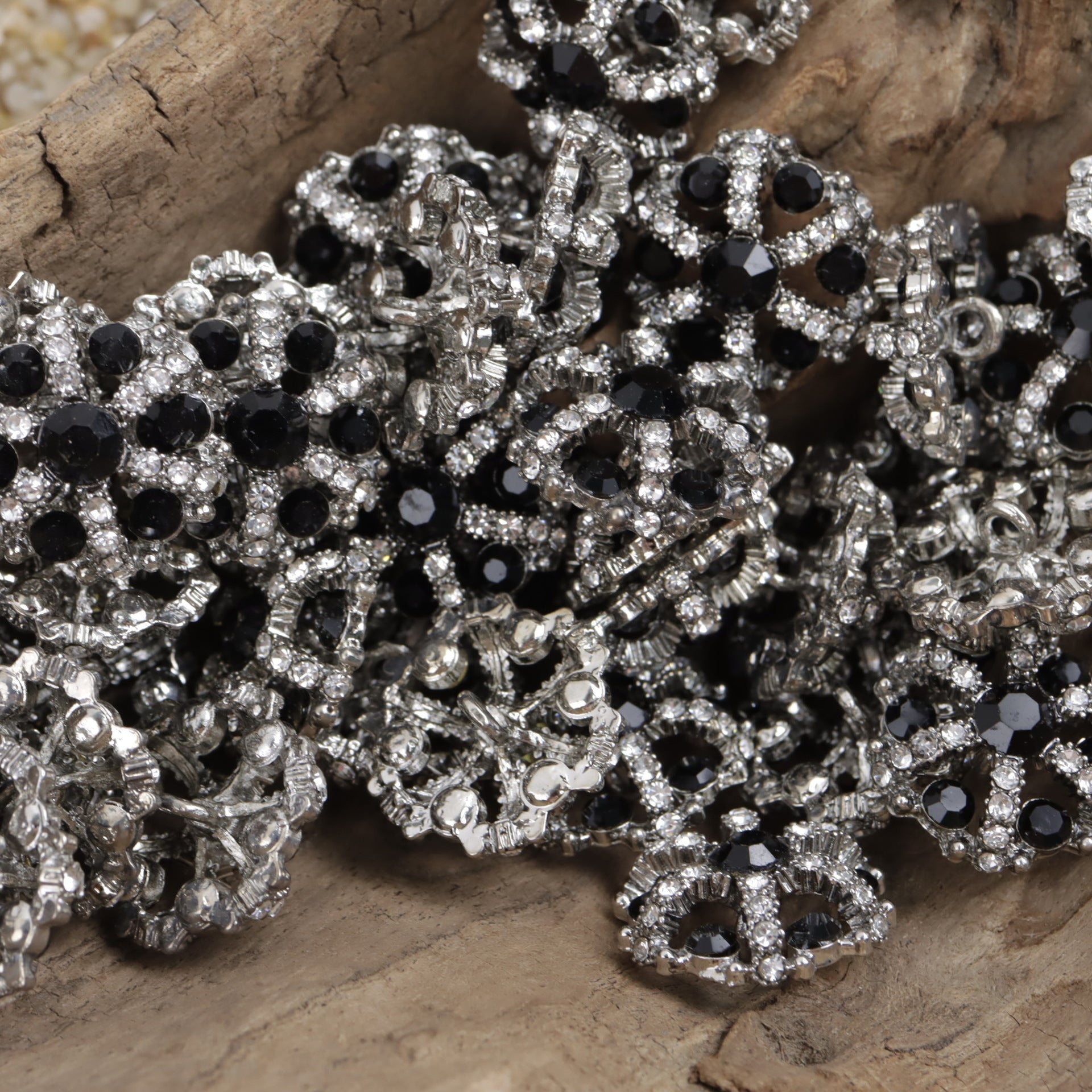 Black irregular snowflake rhinestone inlaid hollow metal buttons, close-up