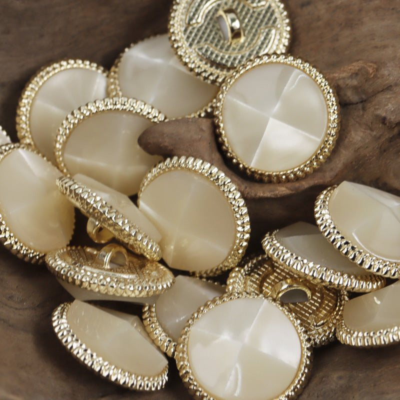 Cream white resin tortoise-shell buttons, gold metal bases, round with ridged rim