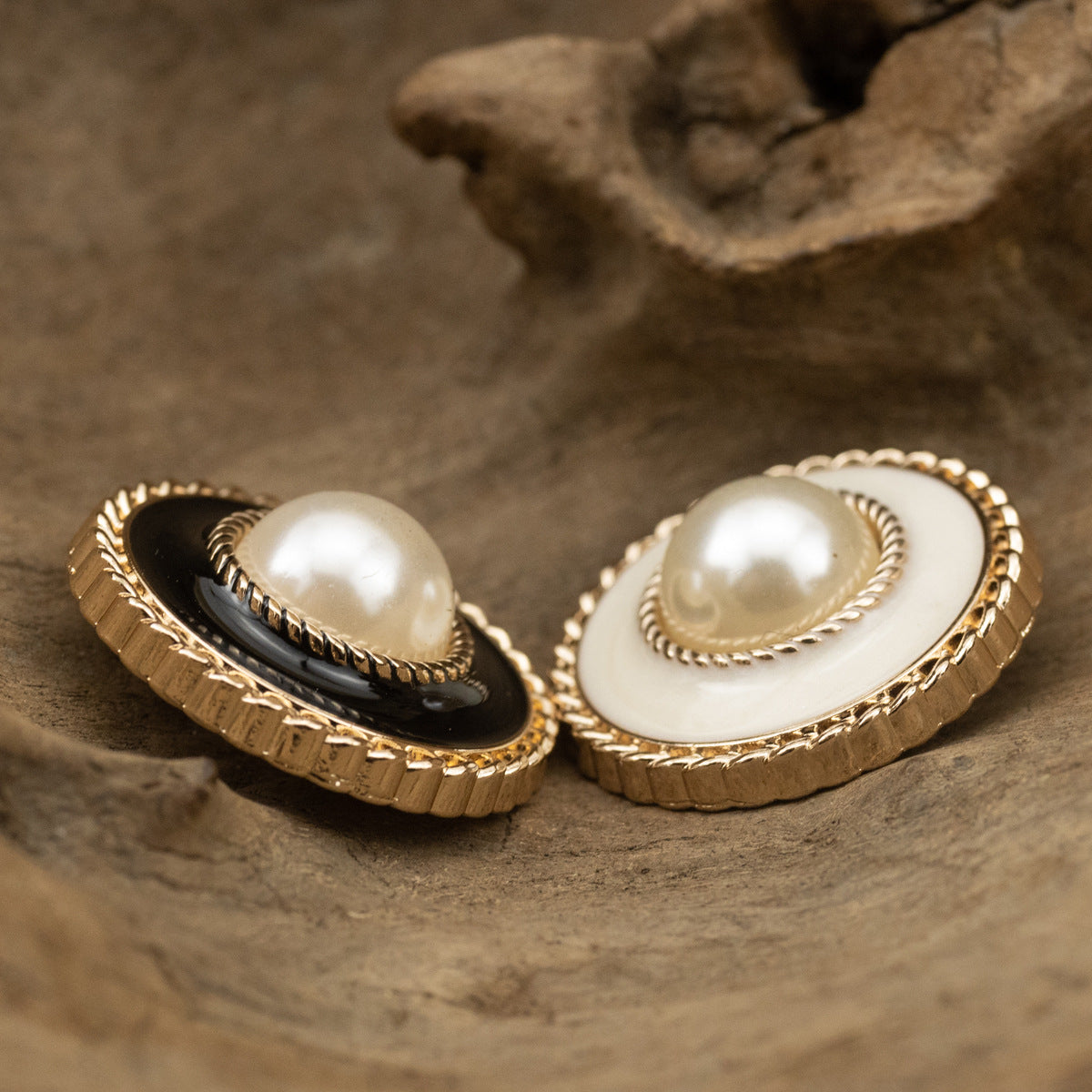 Vintage coat buttons, one black enamel one white, both with gold-tone pearl centers