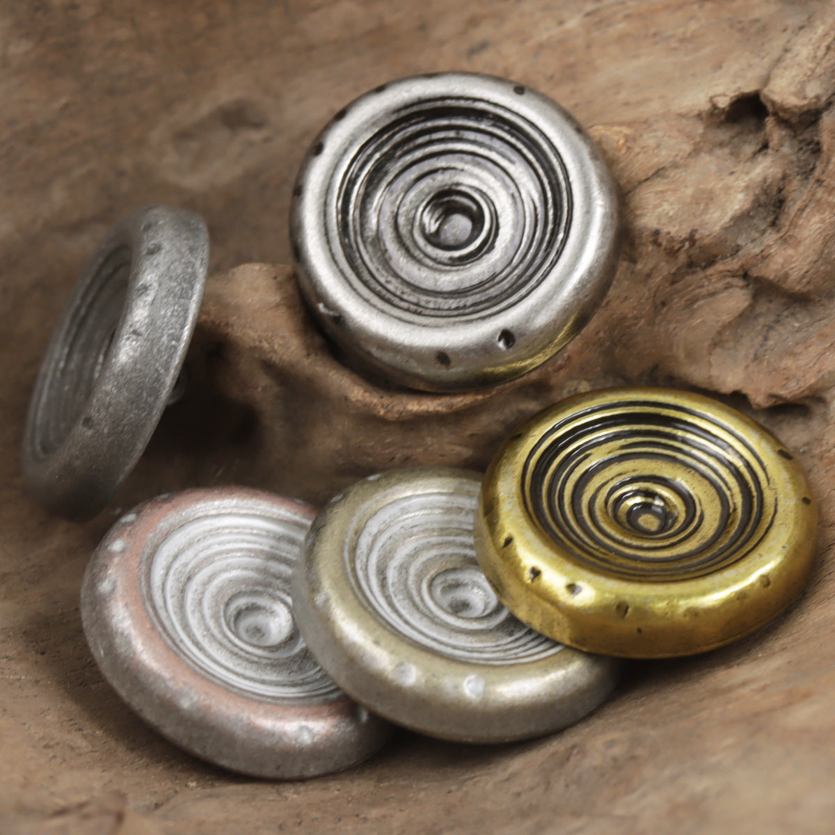 Round bowl-shank metal buttons with concentric spiral detail, silver and bronze