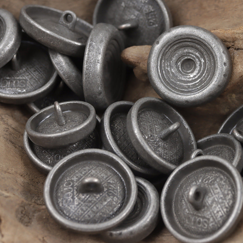 Bowl-shaped metal shank buttons with stamped backs and central posts, silver finish