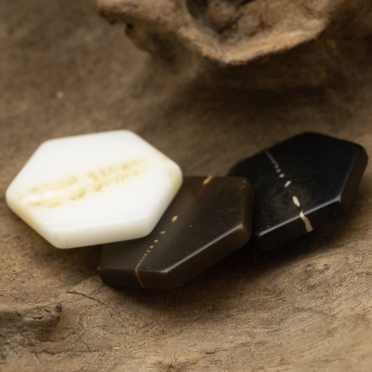 Hexagon resin shank buttons, close-up view of white and dark marbled pieces.
