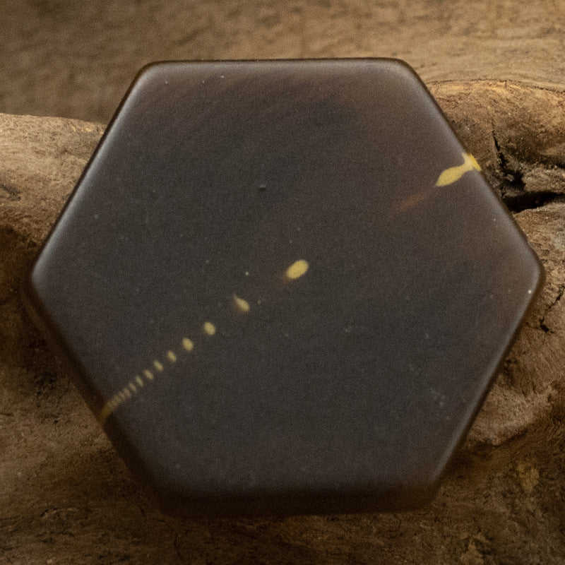 Brown hexagon resin shank button with lighter speckled marble texture marks.
