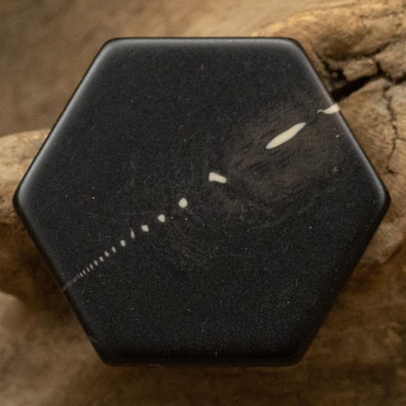 Black hexagonal resin shank button with yellow marble speckle and streaks