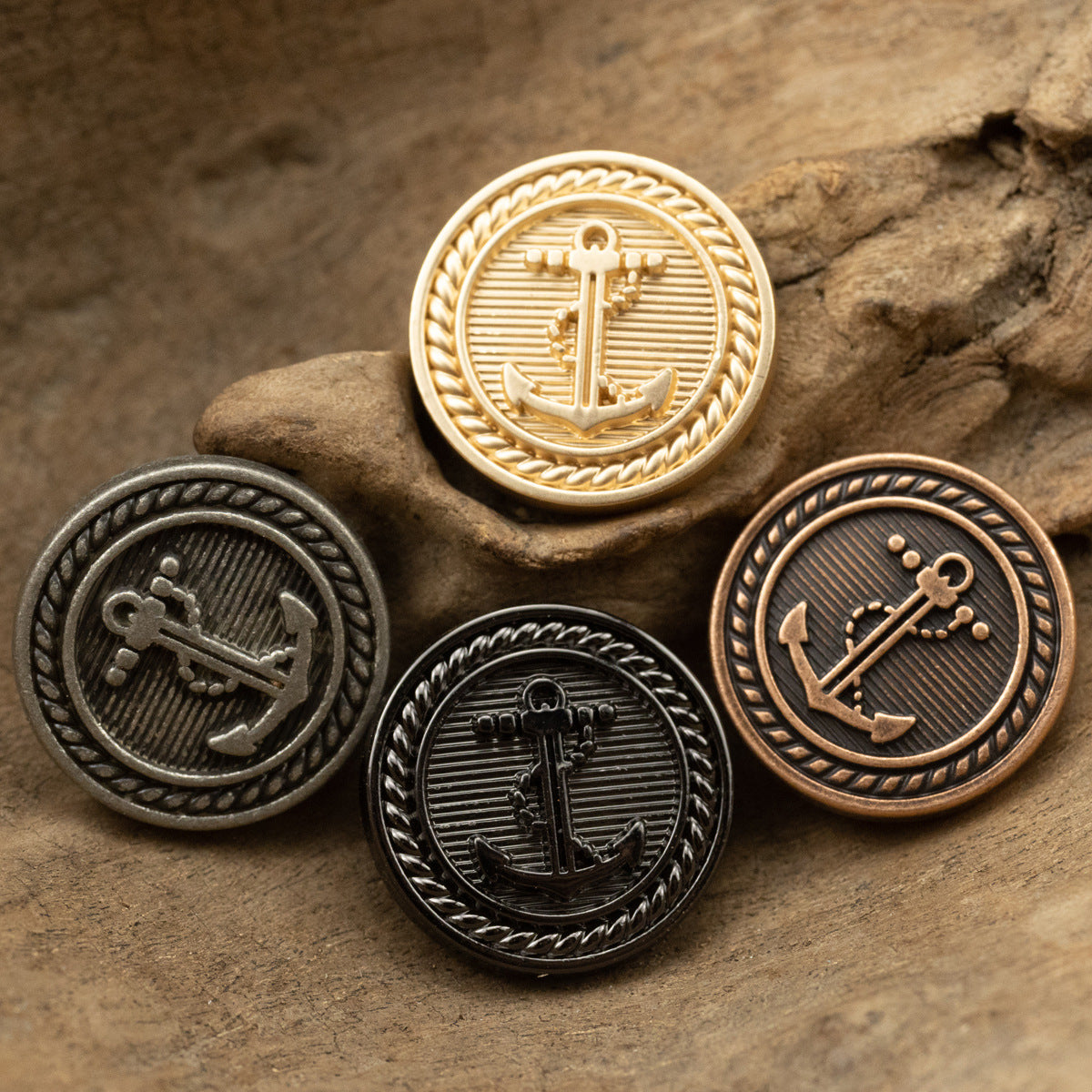 Four nautical anchor metal buttons in gold, silver, red bronze, and black
