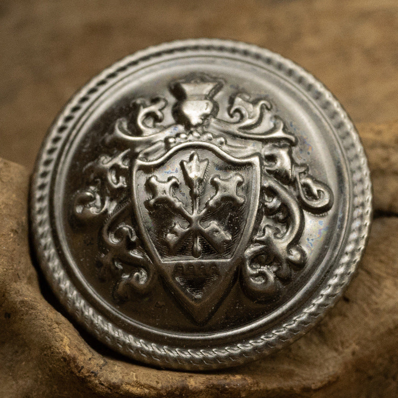 Silver crown crest metal shank button with ornate shield and scalloped edge