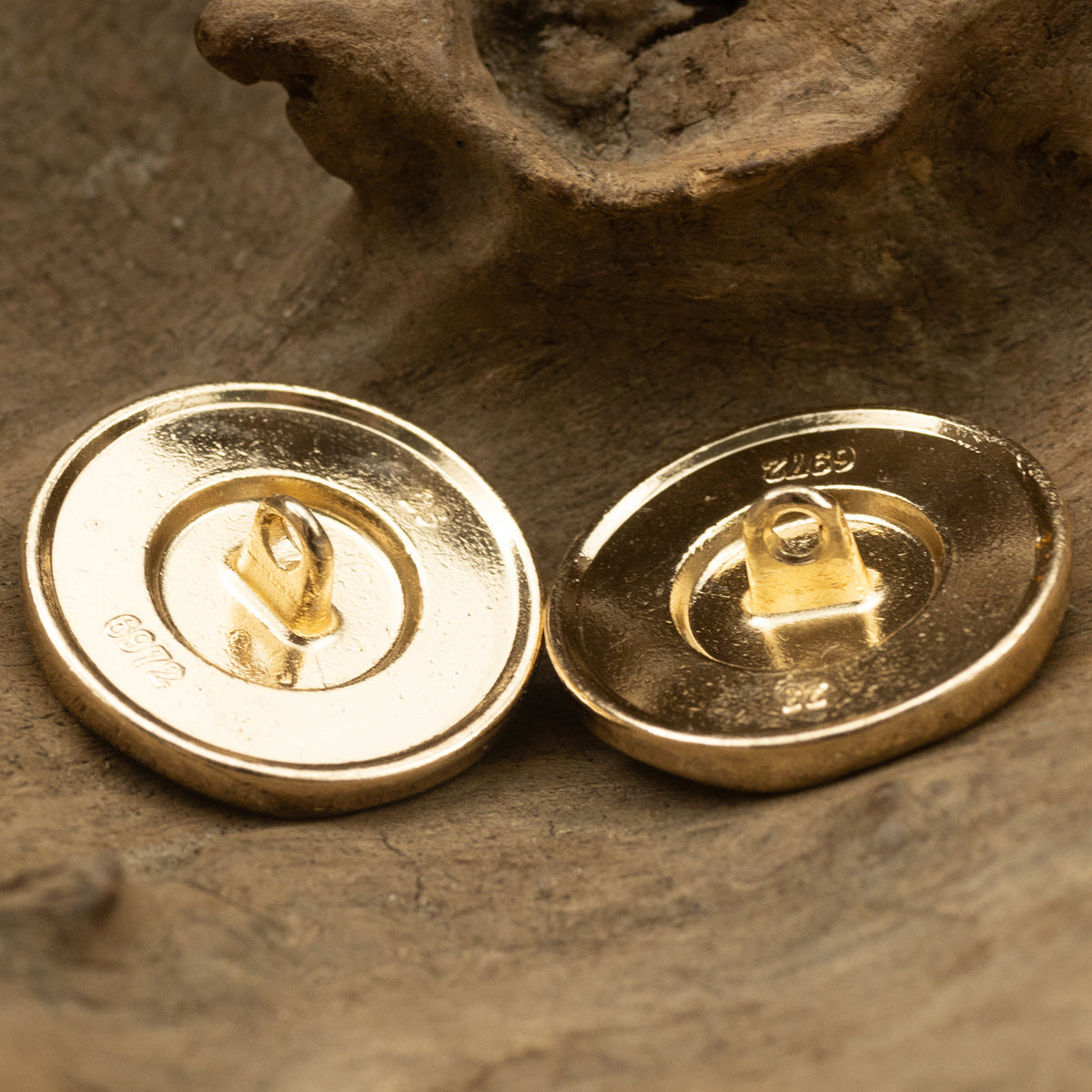 Gold metal jacket buttons showing undersides with shanks/posts