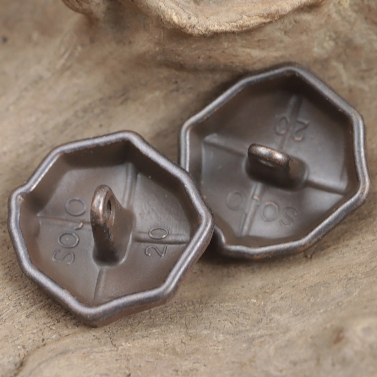 2 dunkelrote Metallknöpfe mit Griff, Rückseiten mit Prägung
