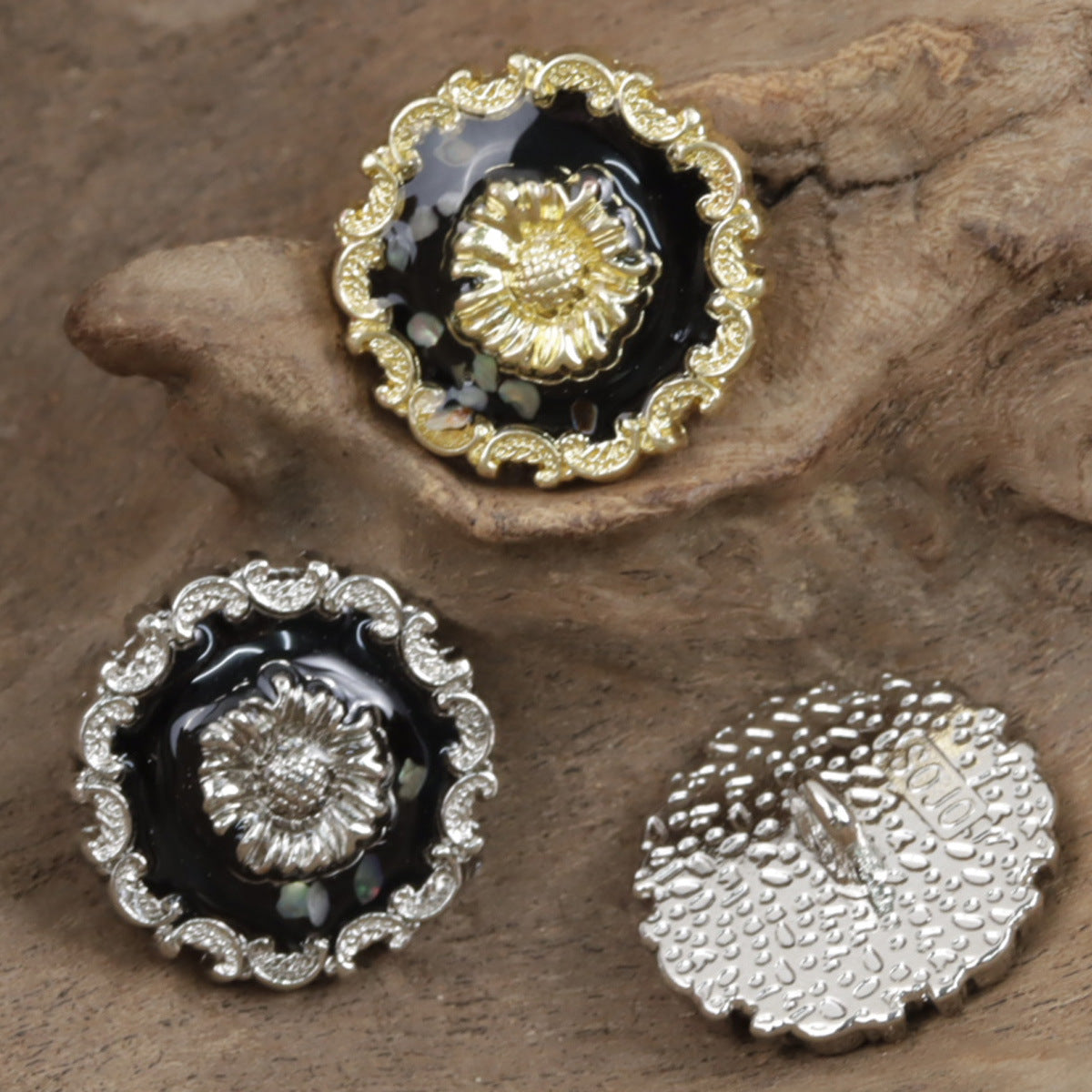 Irregular lace black glued button with gold base, ornate rim and textured center