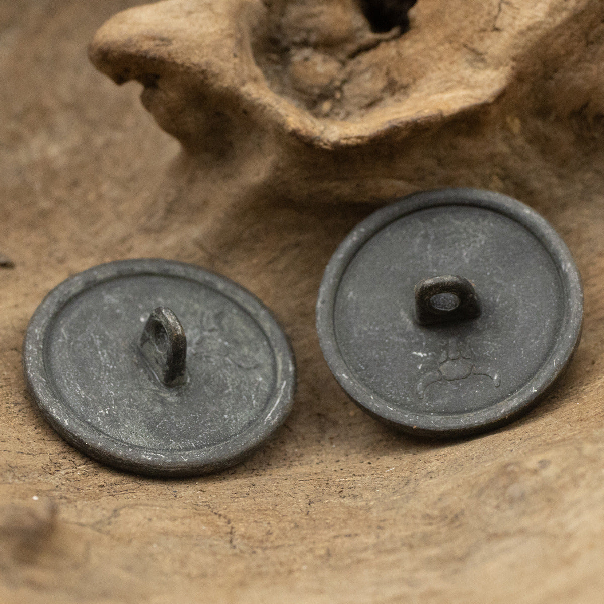 Metal button backs with shanks and central holes, set of two