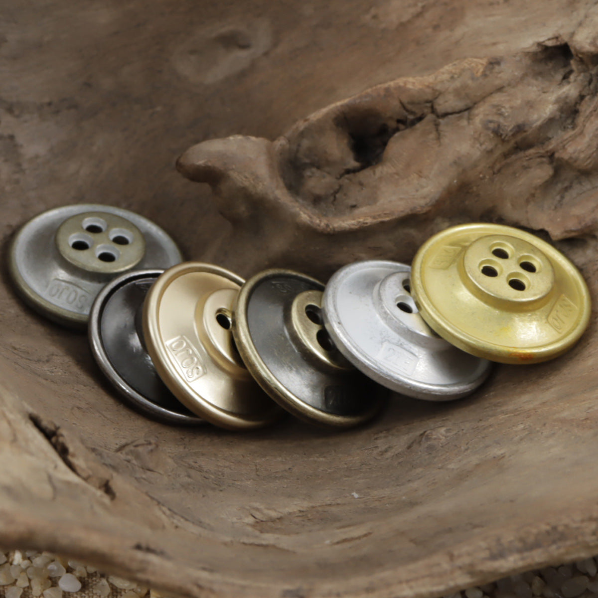 Bowl-shaped metal buttons in bronze, gold, and silver tones with 4-hole fronts