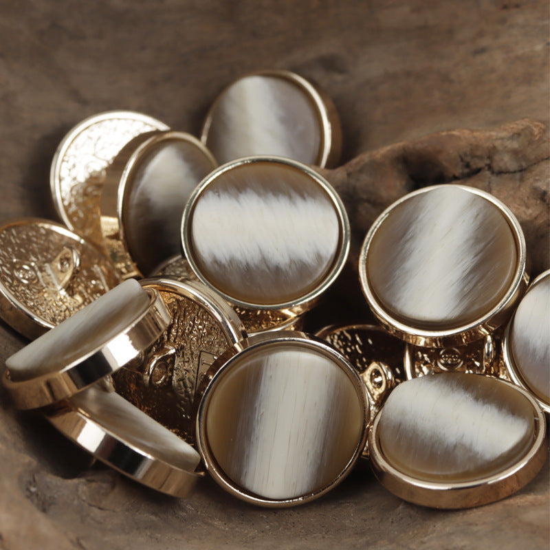Mixed beige, deep gray, and black gold-tone base shank buttons with loop backs