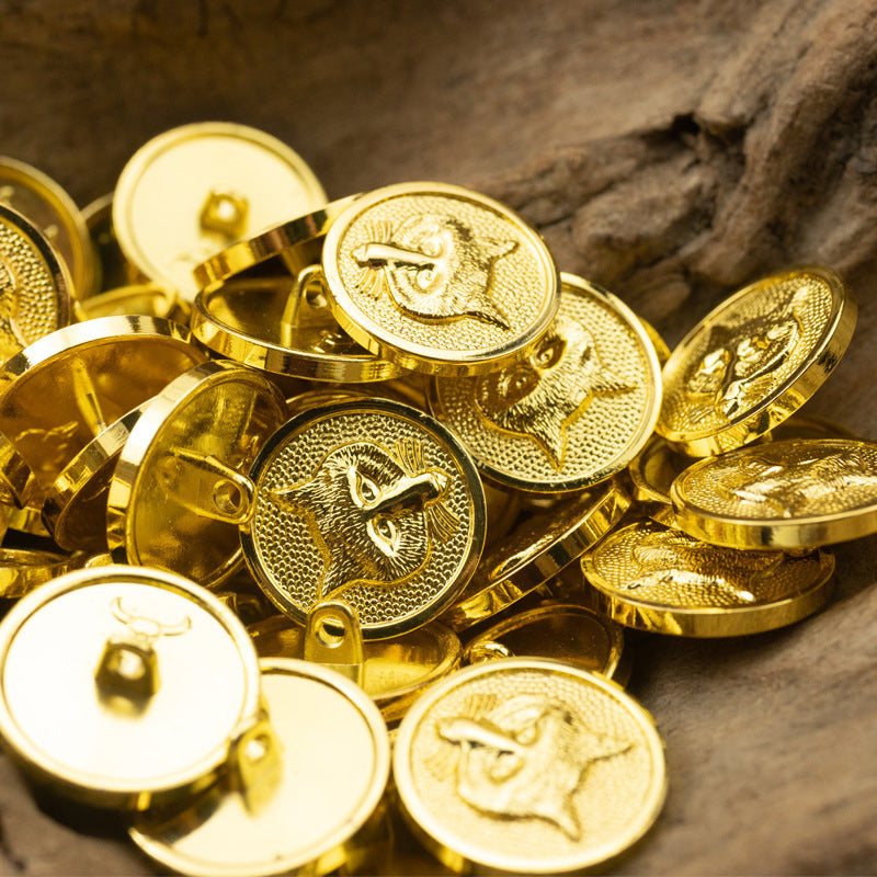 Gold metal shank buttons close-up with fox and nautical-helm style fronts, 6pcs