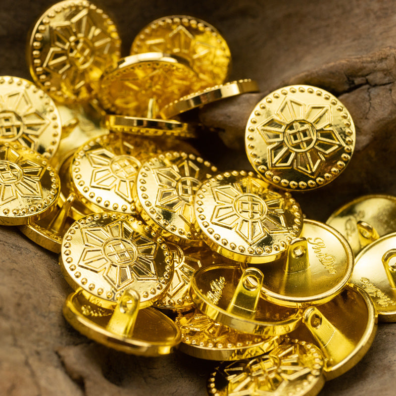 Gold metal shank buttons close-up with geometric starburst and emblem fronts, 6pcs