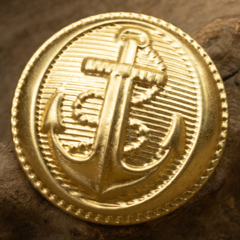 Gold anchor pattern brass button with ridged rim and engraved anchor
