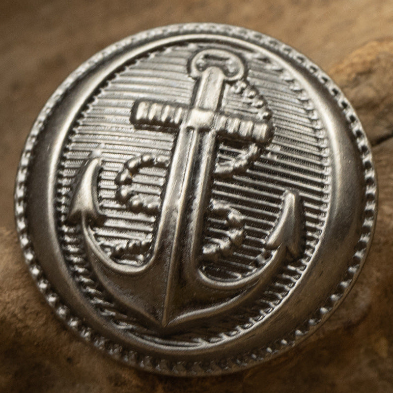Silver anchor pattern brass button with ridged rim and engraved anchor
