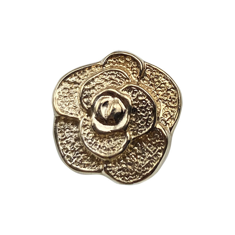 Gold rose metal button with raised floral pattern and glossy center shank
