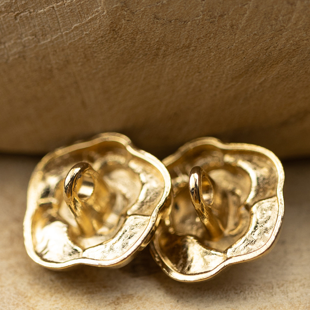 Two gold rose metal buttons shown from the back, with metal loop attachment