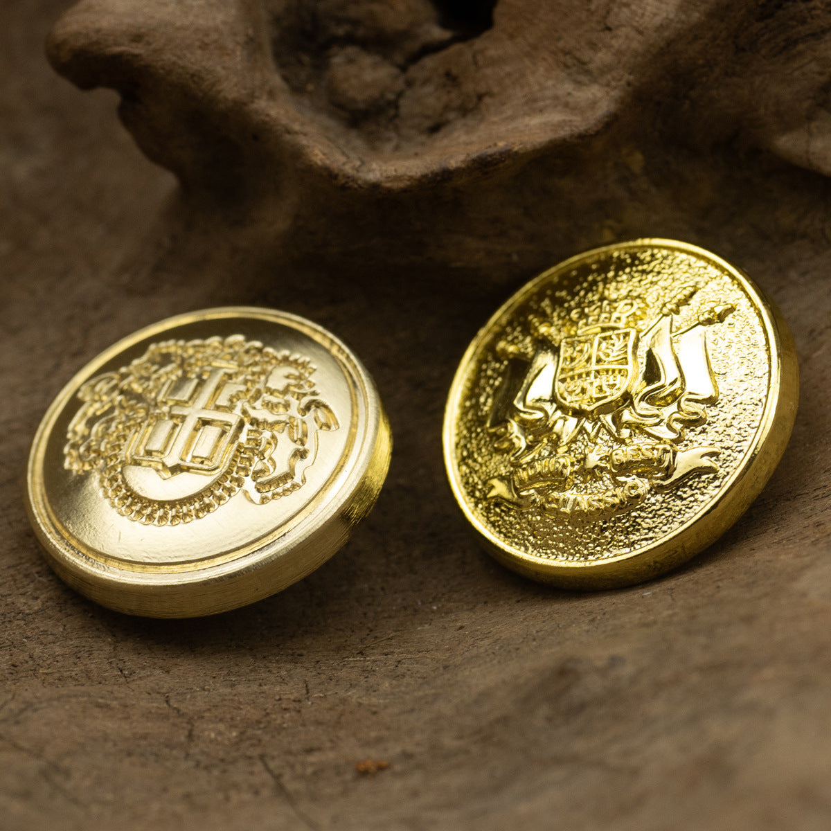 Golden shield metal buttons (2): lion emblem and crest/crown design, front view