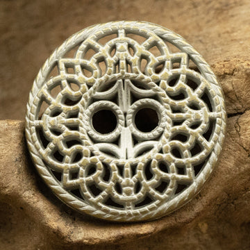 Antique tin bronze decorative button with ornate cutout design, round with 2 holes