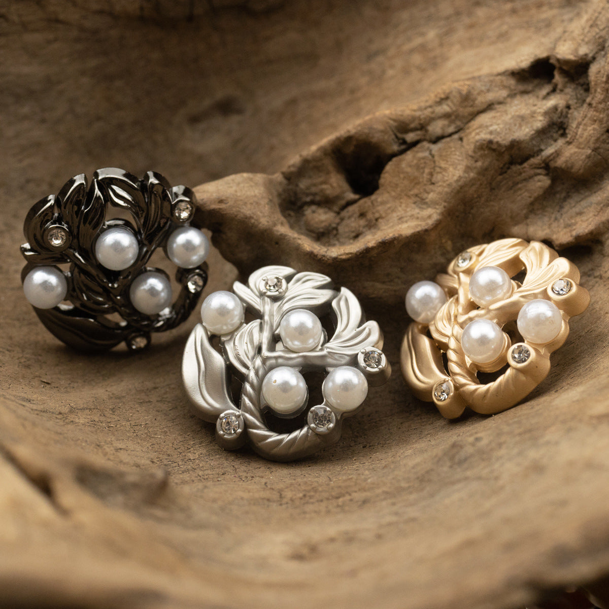Leaf-and-pearl diamond-inlaid metal buttons in dark, silver, and gold tones