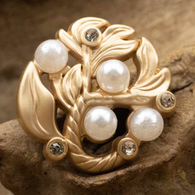 Gold leaf metal button with pearl centers and diamond-inlaid accents