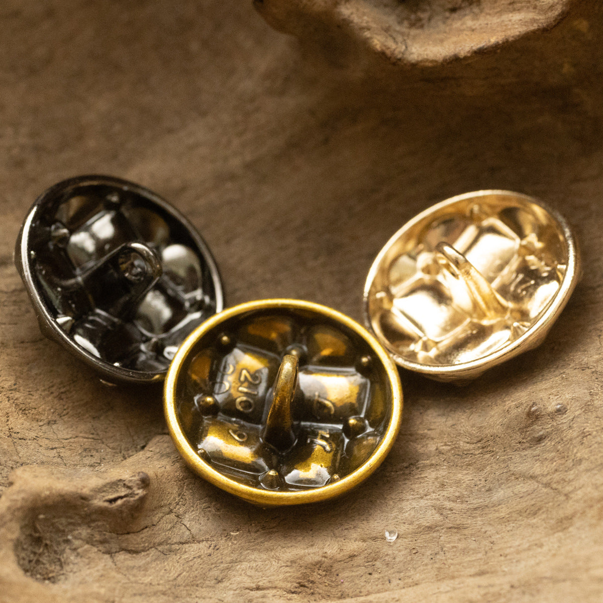 Three diamond woven suit buttons: gold, rose gold, and black with rhinestones
