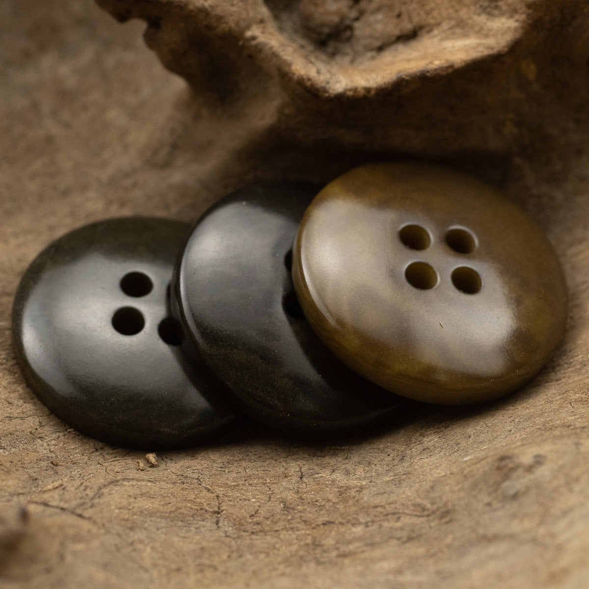 Pair of round 4-hole vintage buttons in matte dark gray and olive-brown