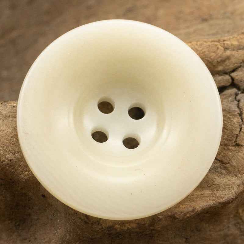 White natural fruit button with four holes, close-up front