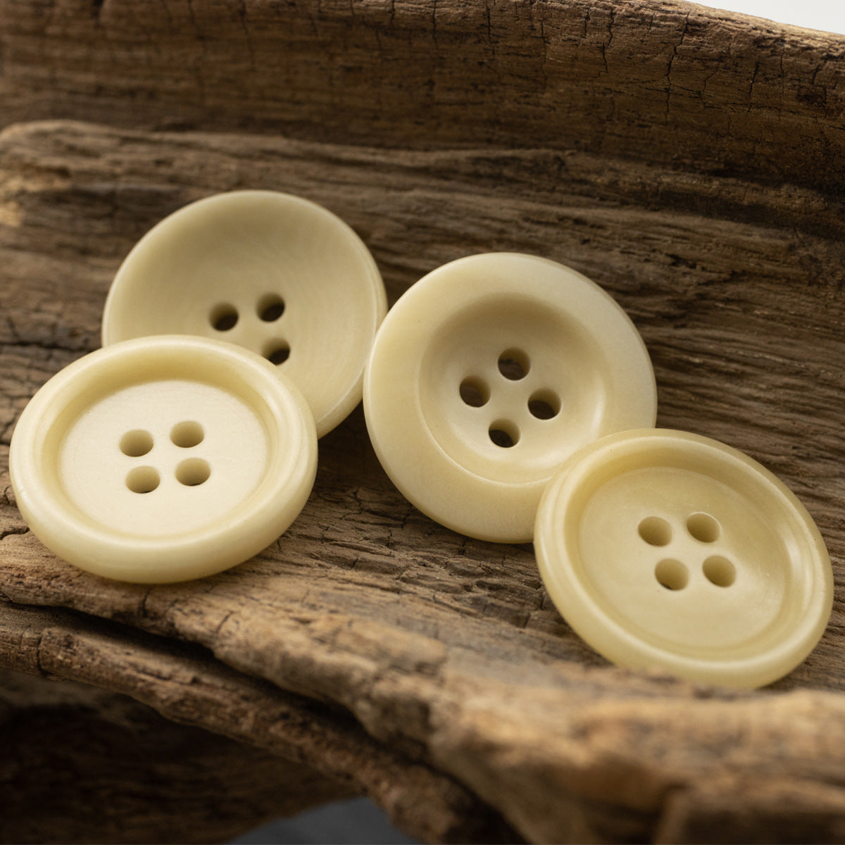 Light yellow 4-hole fruit buttons, side-by-side front views with holes