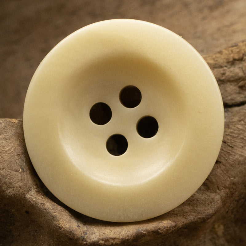 Light yellow 4-hole fruit button, front view with centered four-hole layout