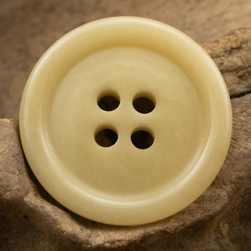 Light yellow 15–20mm 4-hole fruit button, close-up front with four holes