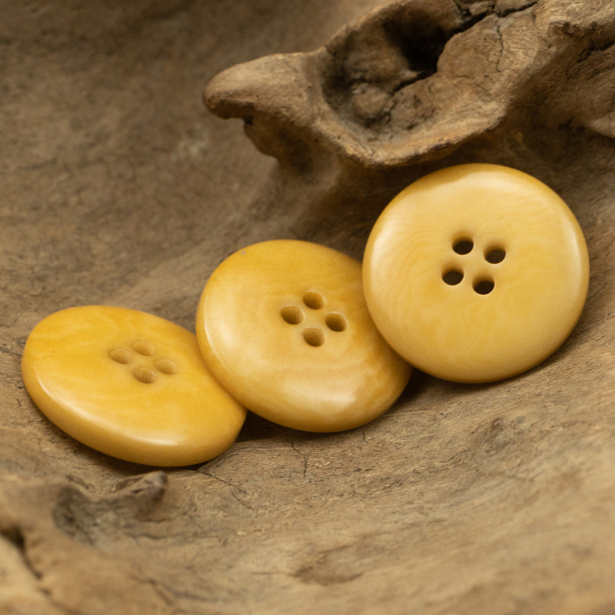 Three yellow round buttons with four-hole centers