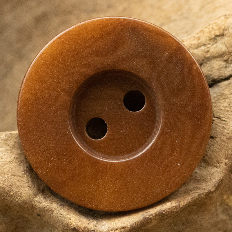 Reddish-brown 2-hole button, round with two holes in the face
