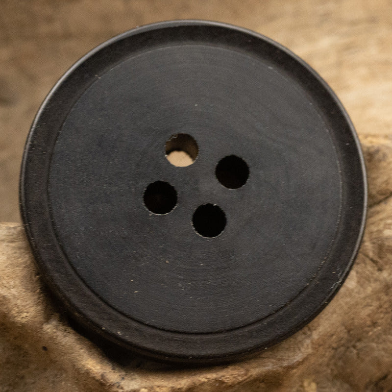 Matte black-brown 4-hole fruit button, 15–25 mm, close-up on button face