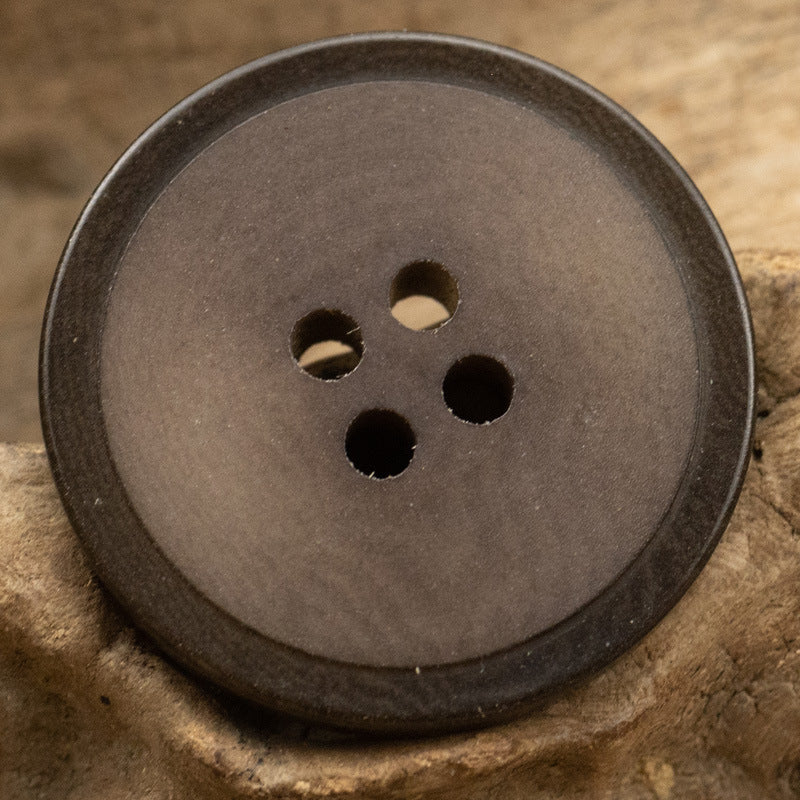 Matte brown 4-hole fruit button, 15–25 mm, close-up on button face with holes