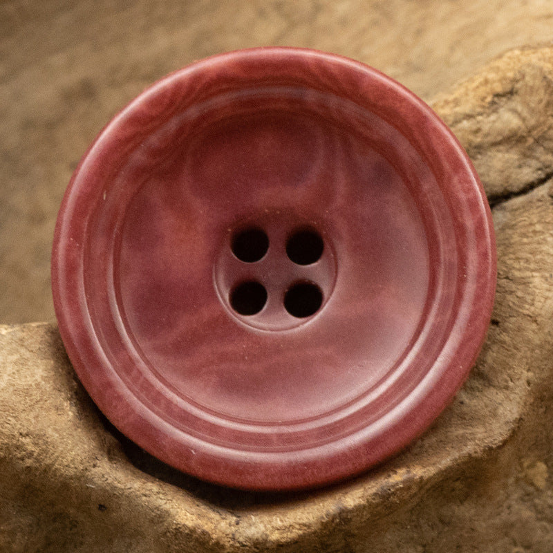 Rose red round 4-hole trouser button with natural swirled finish