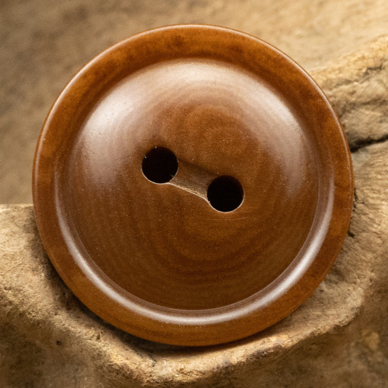 Round two-hole corozo button, rich brown with two holes and glossy grain