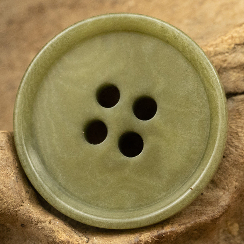 Olive-green round 4-hole tagut nut button, front view