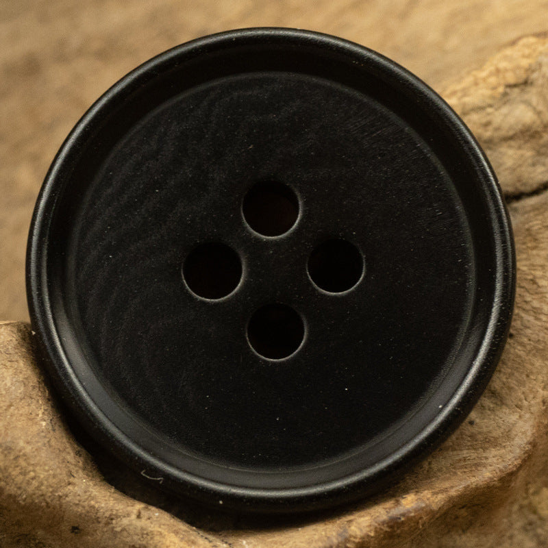Black round 4-hole tagut nut button, front view
