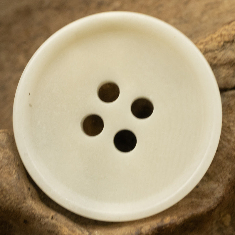 White round 4-hole tagut nut button, front view