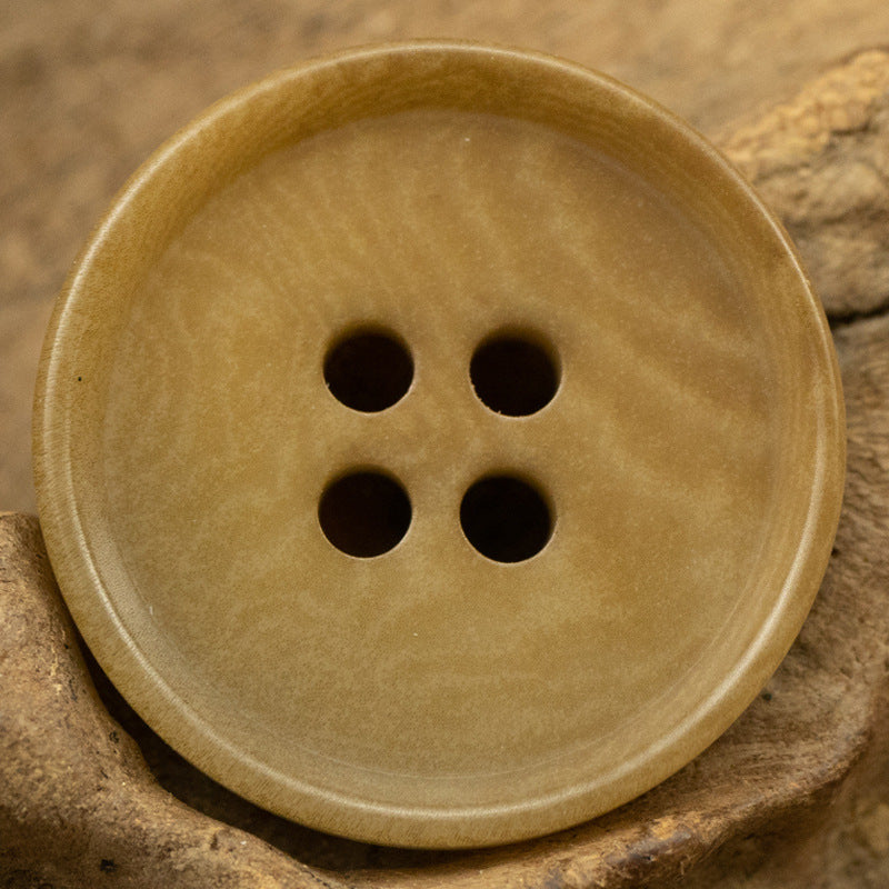 Coffee-tan round 4-hole tagut nut button, front view