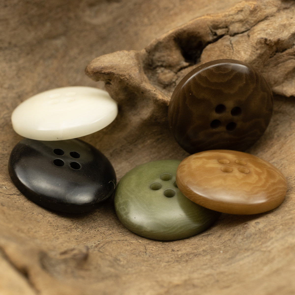 Four-hole tagua nut buttons in white, black, green, brown tones