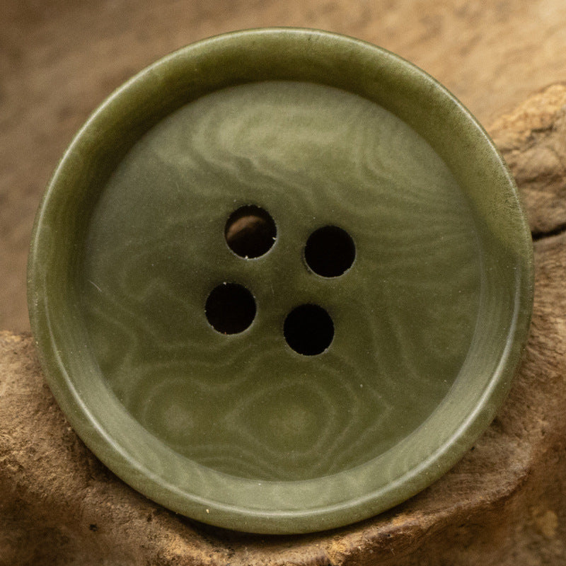 Green four-hole tagua nut button, round with subtle swirling grain