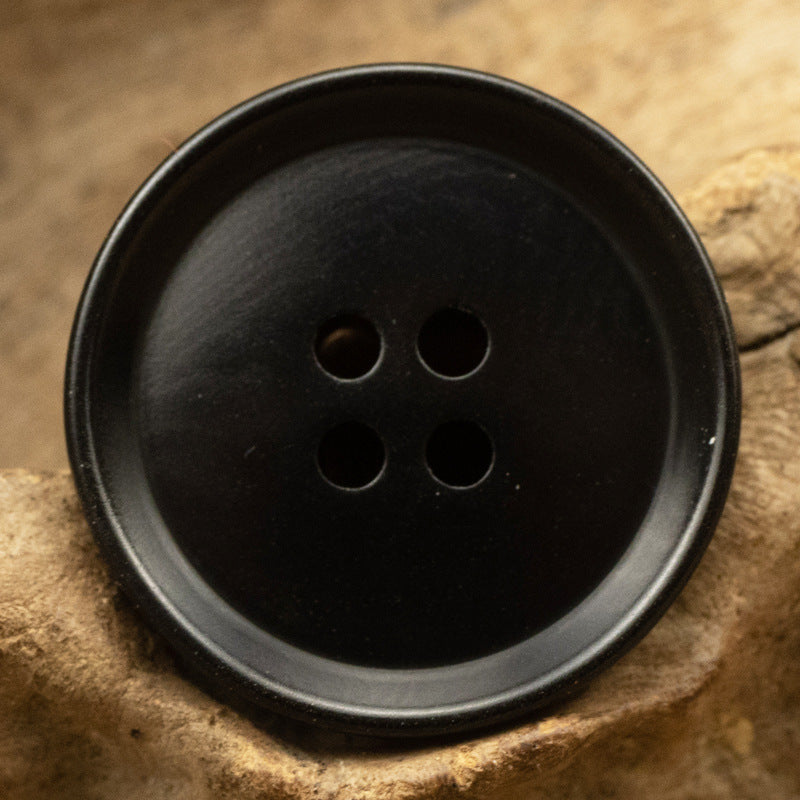 Black four-hole tagua nut button, round with natural marbled grain