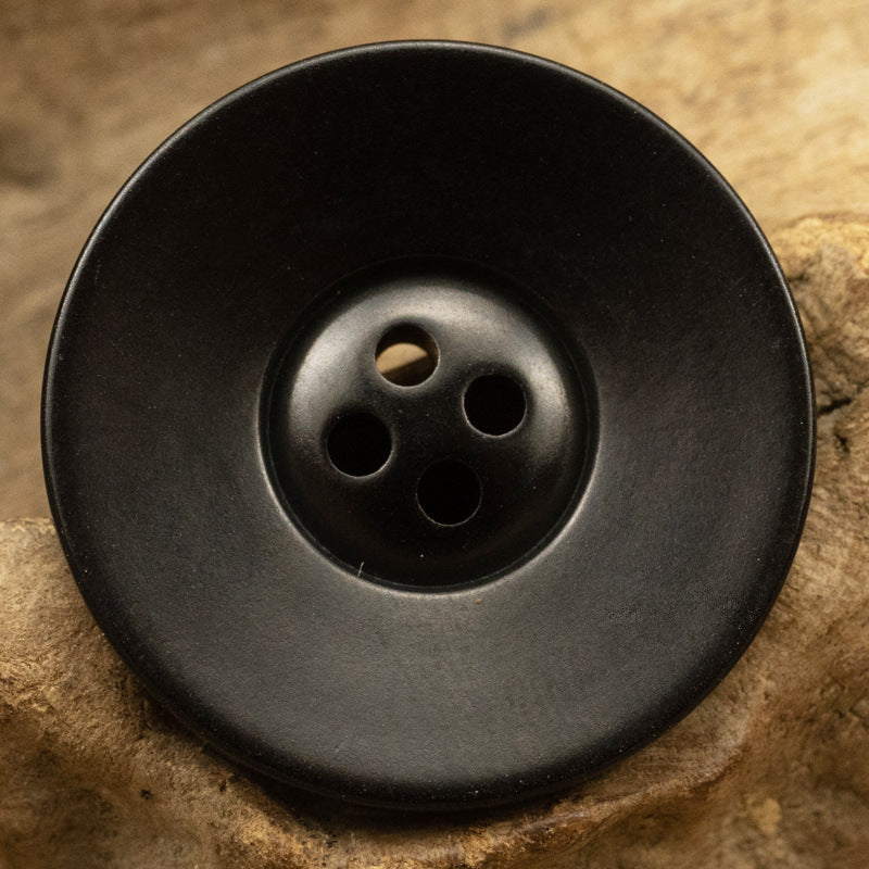 Vintage wide-edged fruit button, black with four holes, round