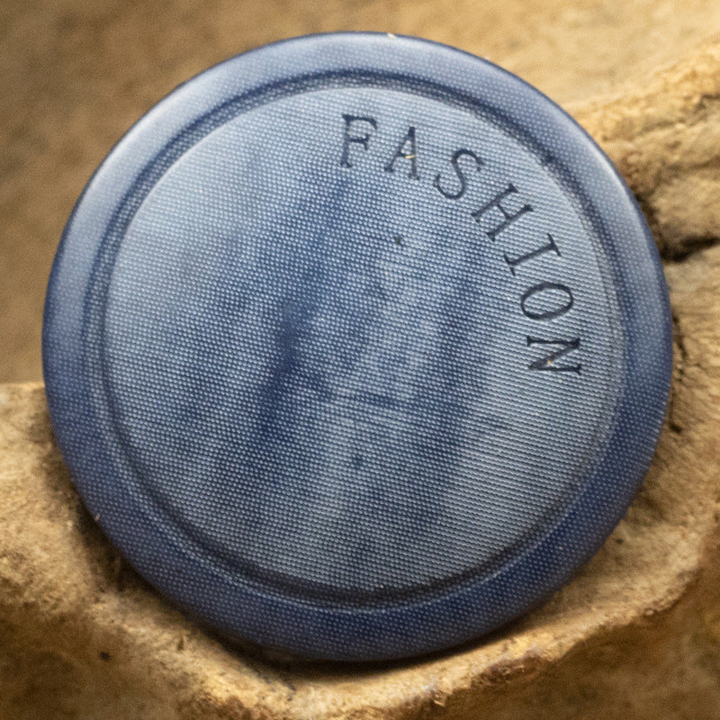 Navy-blue button back with 'FASHION' lettering, round fabric-covered style
