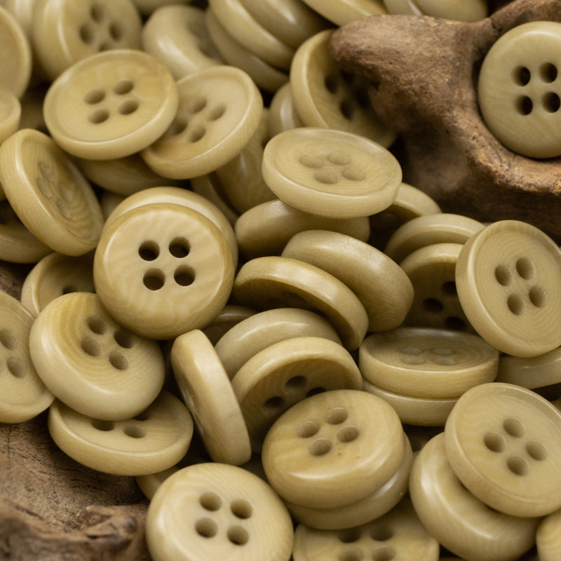 Khaki/gold natural fruit buttons, round fronts with four holes, mixed pile close-up