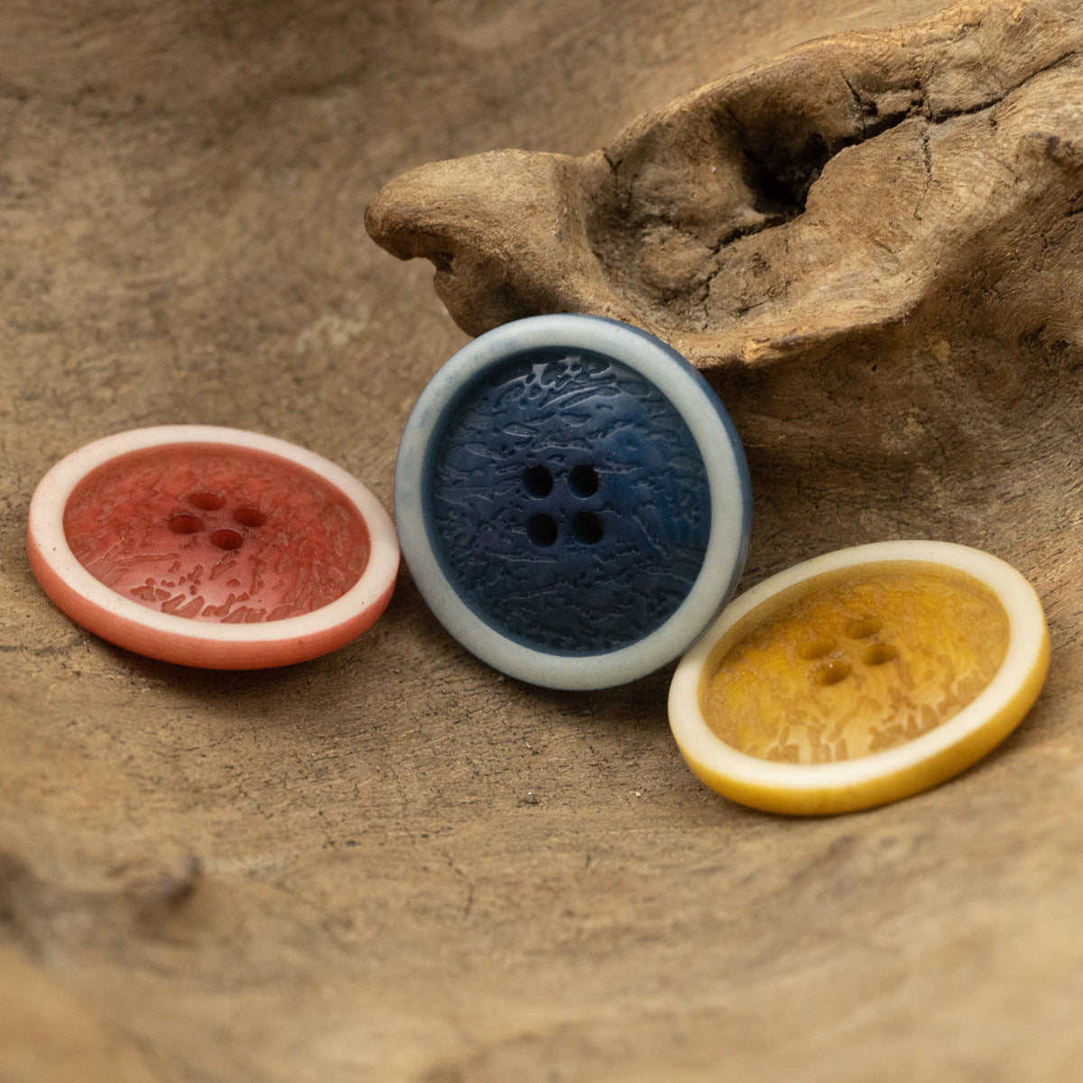 Red, blue, and yellow fruit-pattern buttons with four holes and light outer rims.