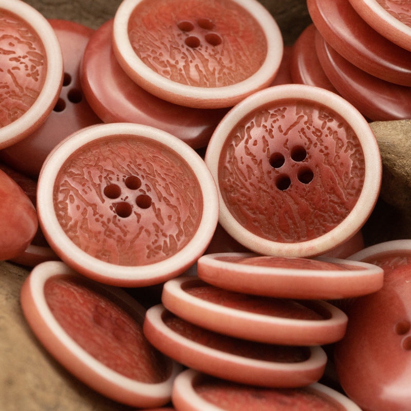Multiple red fruit-pattern cardigan buttons with white rims; each button has four holes.